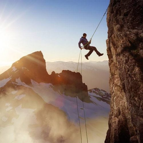 Epic Adventurous Extreme Sport Composite of Rock Climbing Man Rappelling from a Cliff. Mountain Landscape Background from British Columbia, Canada. Concept: Explore, Hike, Adventure, Lifestyle